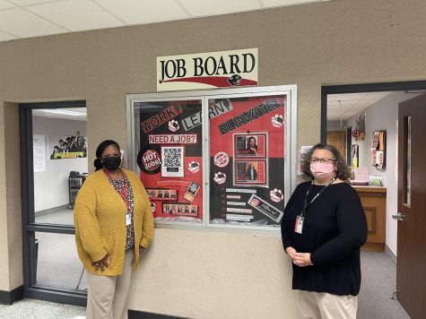 Fowler and Williams pose next to the job opportunities board outside of the attendance office. The board offers advice on how and where to get jobs, as well as how to prepare yourself for them. 