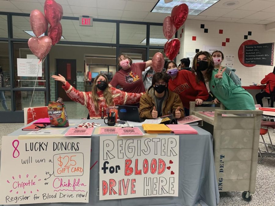 Students sit at the Blood Drive sign up table hoping to get participants for the upcoming blood drive. 