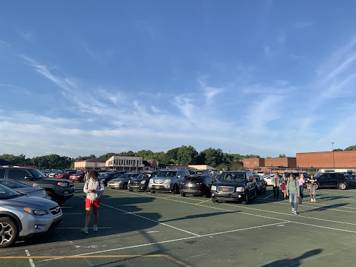 Junior drivers walk through the tennis court lot in the morning.