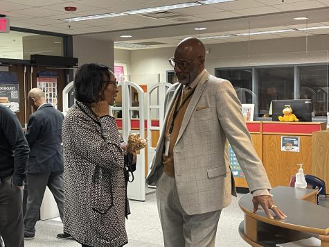 Dr. White (right) speaks with a member of the staff on Thursday, his first day.