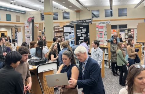 Students display their exhibits together in a gallery-walk style, presenting their research to passerby. 