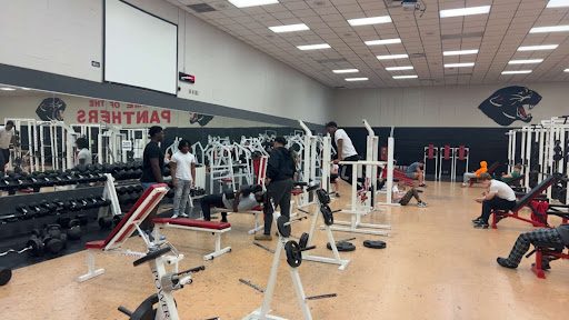 Students lift in the weight room.