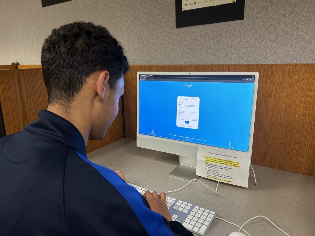 Junior Nadir Boudje works on his college applications in the library. Boudje was hoping to get ahead on applications before a stressful senior year. 