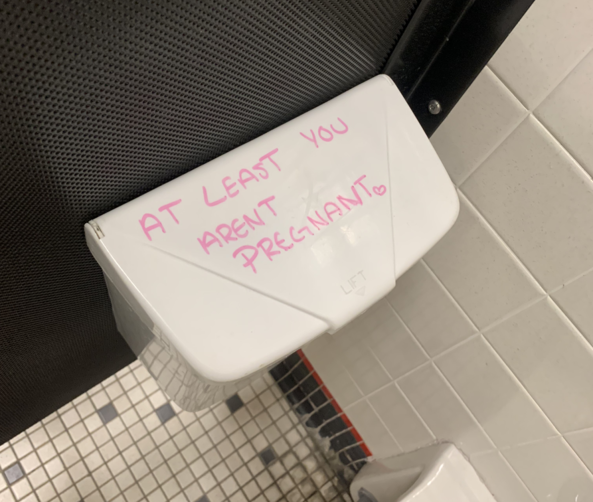 "At least you aren't prengant" is written inside a bathroom stall. Similar message are found in bathrooms throughout the school.