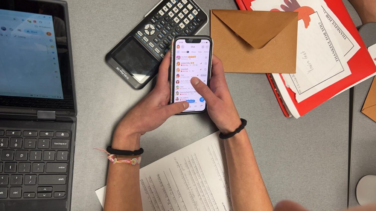 A student check Snapchat during class. Students commonly send snaps during their freetime in school.