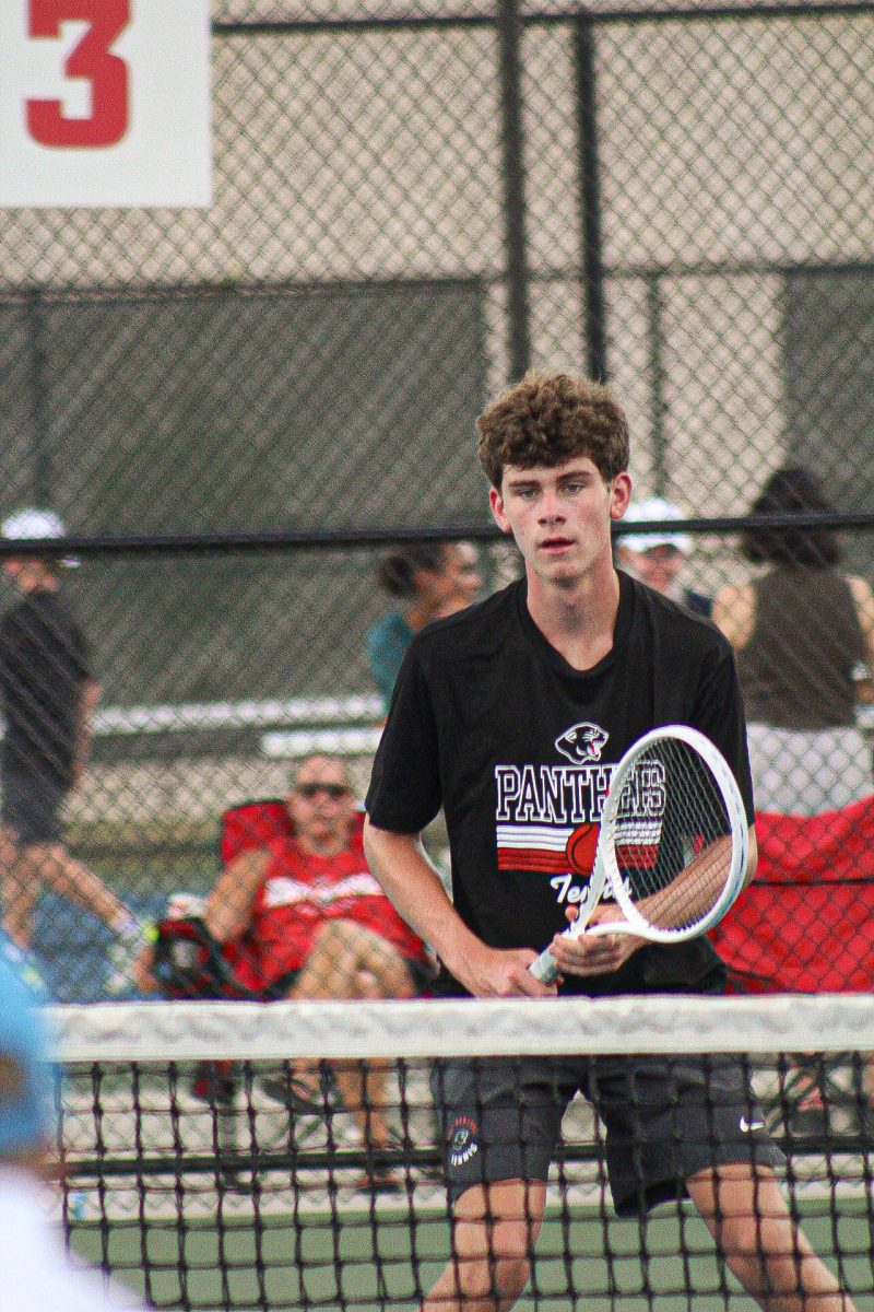 Bryce Harris, a sophmore, prepares againts his opponent during a tennis match against University High School. The boys tennis team had a full varsity scrimmage for both singles and doubles players.