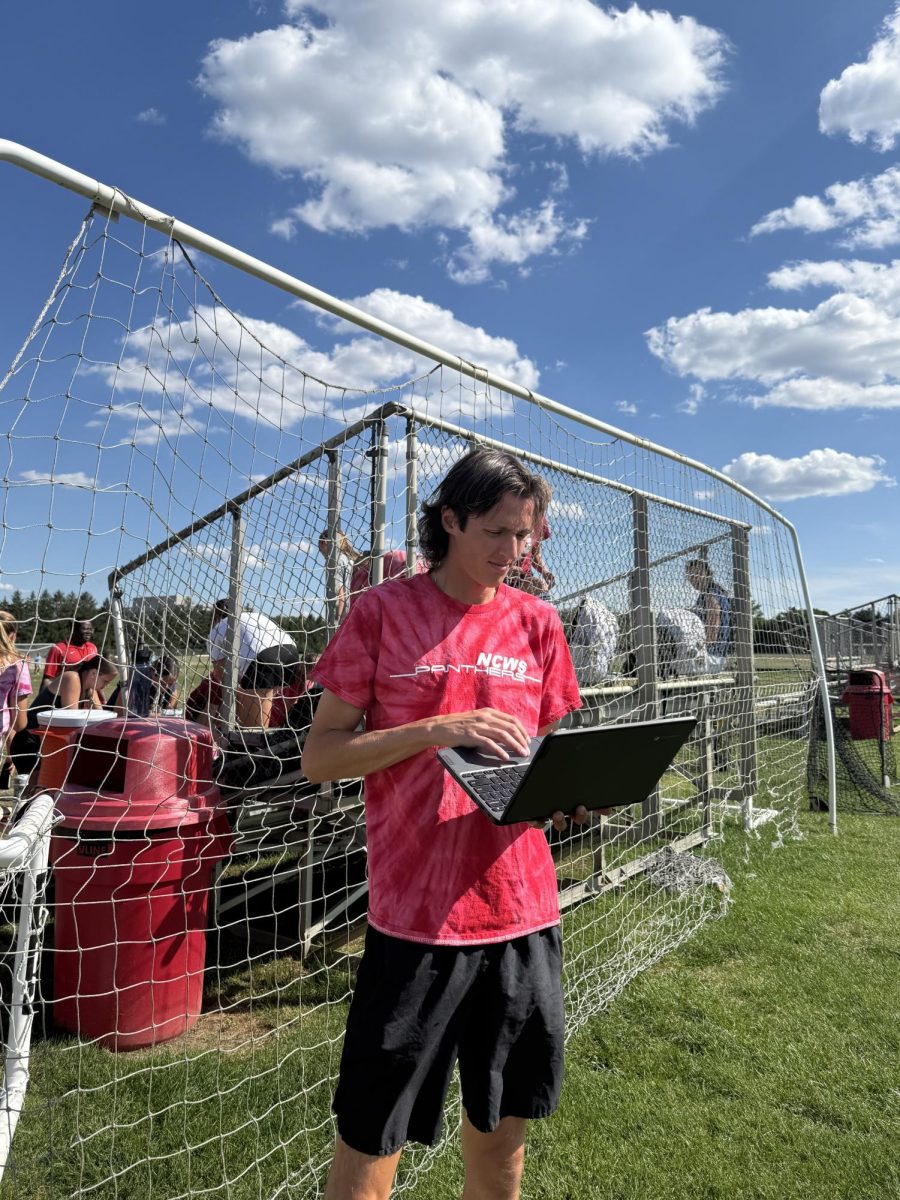 Math teacher Jimmy Lawson balances his work with coaching while his players get a water break. 
