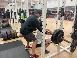 Senior Max Roberts performs front squat with Coach Conor Andras spotting him.
