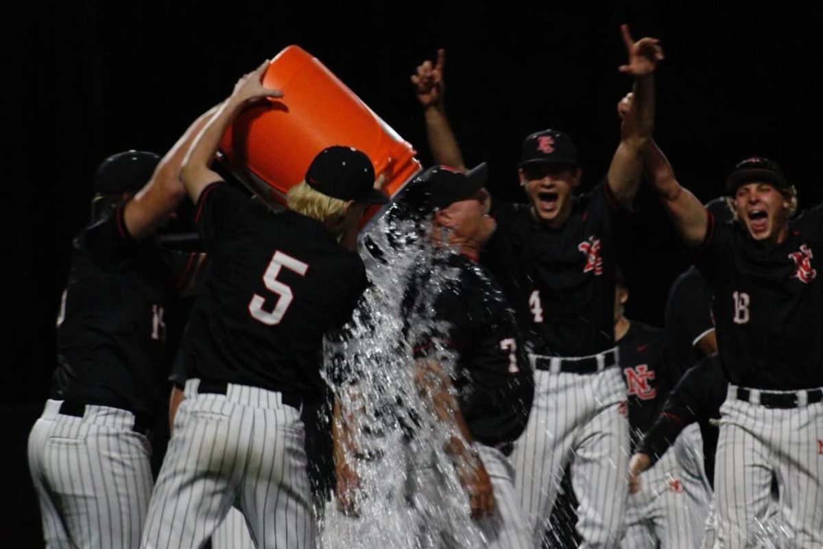 Baseball team showers Coach McClain with water after defeating Lawrence North in the Sectional Championship