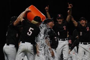 Baseball team showers Coach McClain with water after defeating Lawrence North in the Sectional Championship
