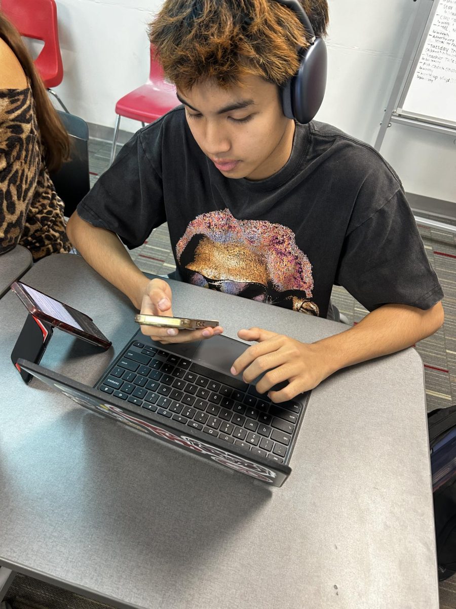 Junior Hein Walar spending class time on his phone instead of doing work. 