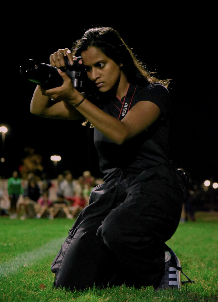 Isa George focuses the lens for the perfect shot. Taken at an NC soccer game. “I needed to learn how to find beauty in the world, and photography really helped me find where life is still beautiful, “ George said.