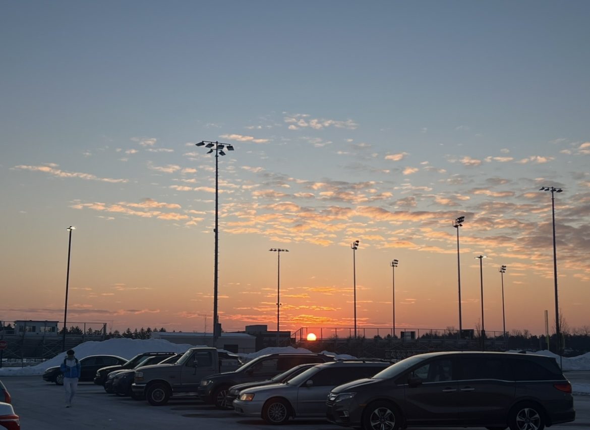 The sun rises behind the junior student parking lot. "Honestly, from freshman year to now, morning practices have become much easier for me. I try to get around seven hours of sleep before them to reset my mind and body,” junior Elijah Anderson said.