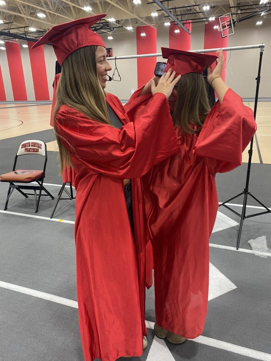 Seniors Carlise Leppert and Lucinda Dilts taking photos trying on their cap and gown for graduation. North Central Graduation is on May 27th 2026. “ It was super exciting and fun to see what I will look like in may as a graduate," Leppert said.
