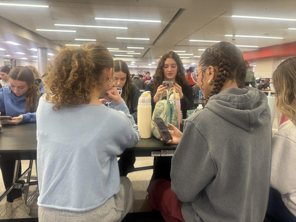 Juniors Sloane Moreland and Ruby Brown scroll on their phones. ¨A reason why social media can have a negative effect on your life is because it can cause you to compare your life to other people.¨ Junior Sloane Moreland said. They scrolled for the rest of the lunch period.