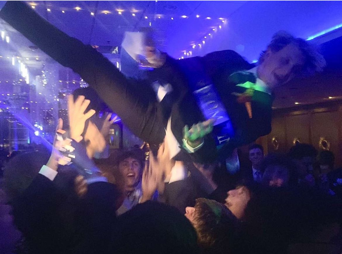 2025 prom king Camden Rhoades lifted into air by other students after winning prom king.